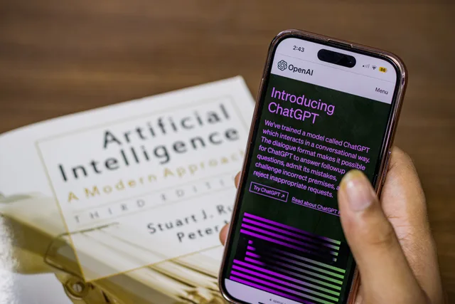 Close-up of a smartphone displaying ChatGPT app held over AI textbook. How to test and control AI use in an accounting practice before relying on it