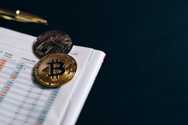 Close-up of Bitcoin coins on a financial report on a dark surface. Accounting services measurement: a practical guide